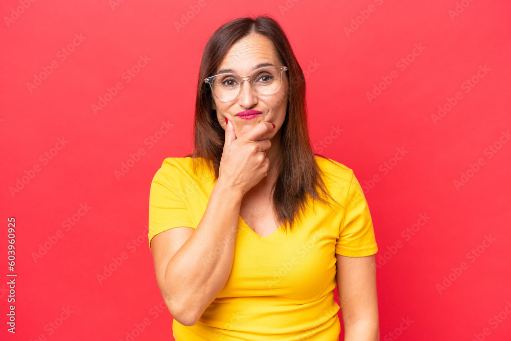 Middle-aged caucasian woman isolated on red background having doubts Middle-aged caucasian woman isolated on red background having doubts