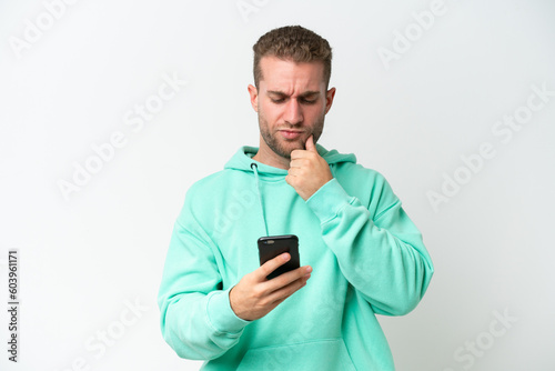 Young handsome caucasian man isolated on white background thinking and sending a message © luismolinero