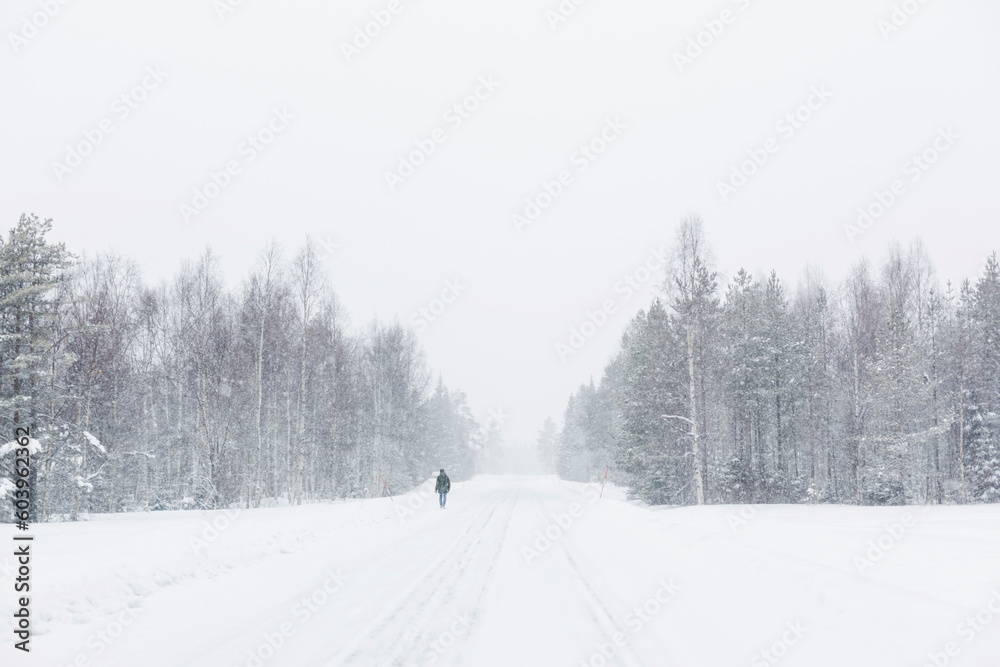 Man walking in snow on road Man walking in snow on road
