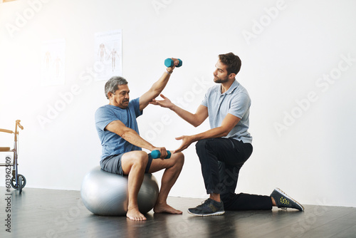 Dumbbells, physiotherapy and exercise with doctor and old man for rehabilitation, training and balance. Health, pain and healing with senior patient and physiotherapist for consulting, muscle or help photo