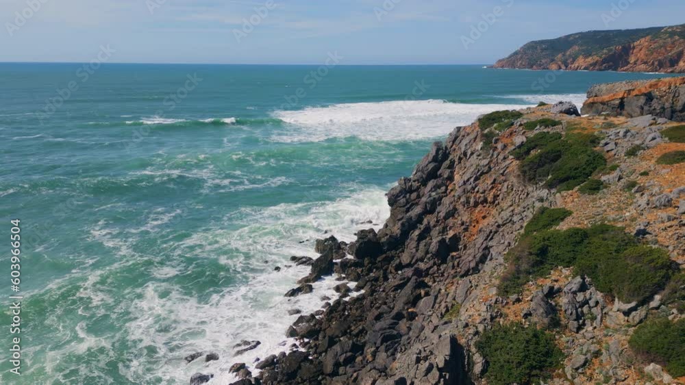 Powerful ocean meeting rocky coast splashing. Rough sea water foaming drone view