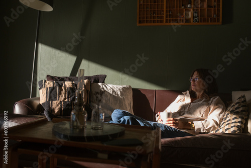 Woman sitting on sofa with coffee cup photo