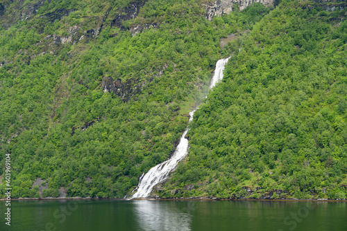 Beautiful landscape with snowy mountain peaks and waterfalls in Geiranger fjord, Norway