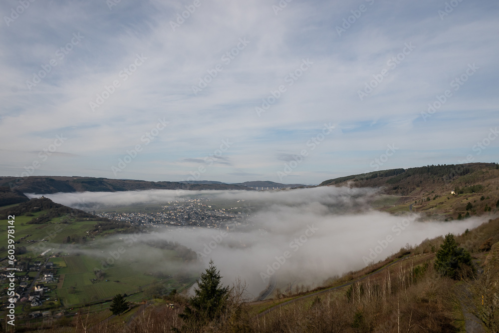 mosselle valley wine region in Germany filled with morning mist fog just after sunrise before the sun burns it off. dragons breath creates dreamy effect in natural beauty with perfect blue sky
