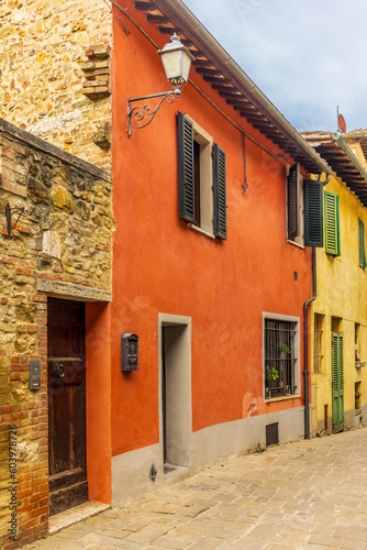 The colorful medieval houses and alleys of San Quirico d'Orcia in a sunny spring day © gdefilip