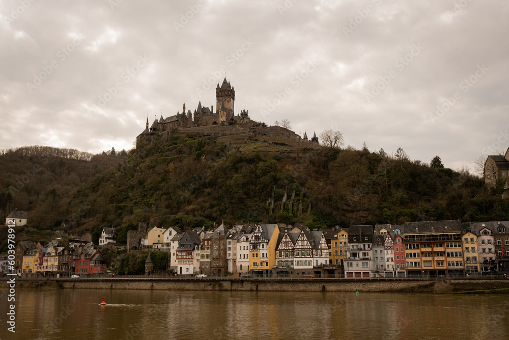 Cochem Castle or Reichsburg imperial impressive medieval historic building tower over old town with river Mosselle in German valley in Europe is popular landmark tourist attraction on sunnny day