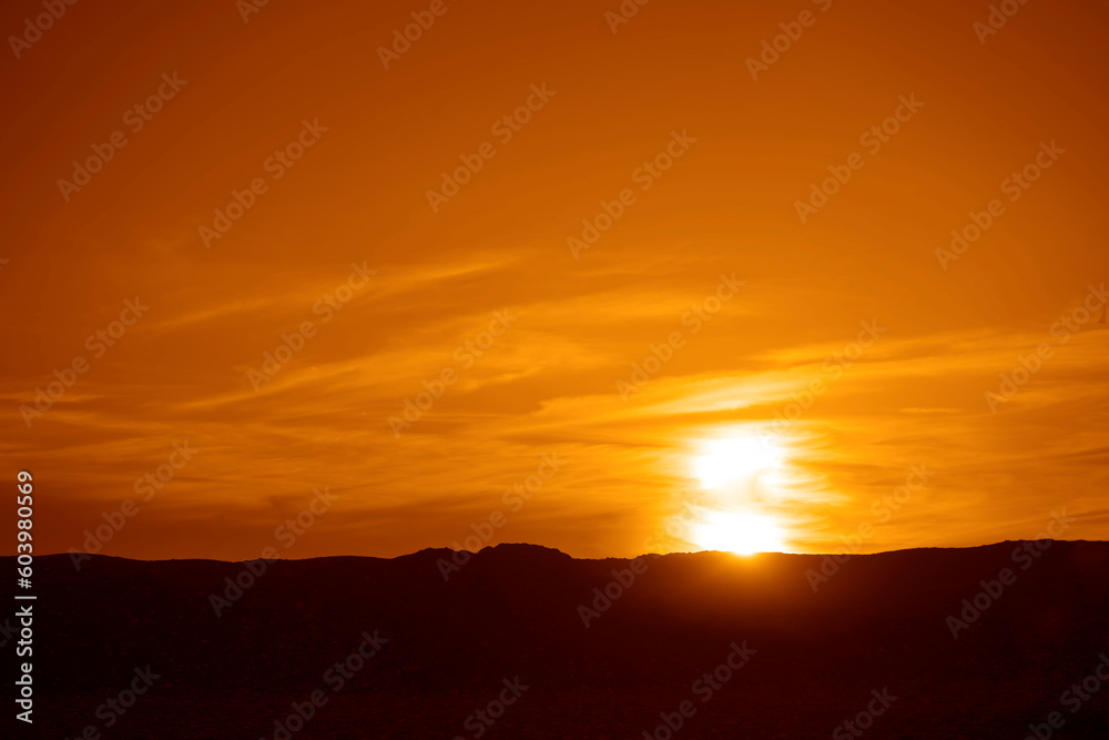 Dramatic Sky with a Black Mountain Silhouette in foreground, Play of Light and Shadow. sun set above horizon line. Dramatic Sky with a Black Mountain Silhouette in foreground, Play of Light and Shadow. sun set above horizon line.
