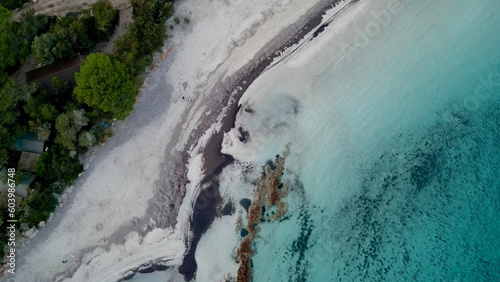 Breathtaking Aerial View of Santa Giulia Beach, Porto-Vecchio, Corsica: Pristine White Sand, Crystal-Clear Blue Waters, Lush Greenery, Hidden Homes, and a Vibrant Coral Reef