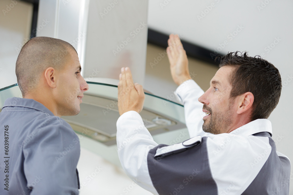 Fototapeta premium contractors discussing the installation of a kitchen extractor hood