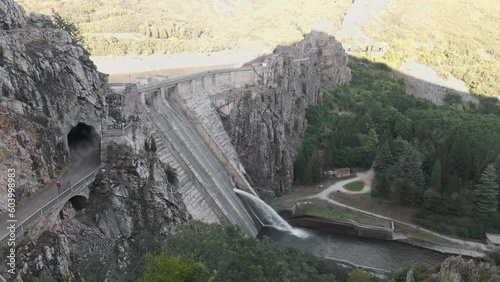 engineering and architecture project of a water dam in the mountains with trees in the forest to generate and store electrical and potential energy 