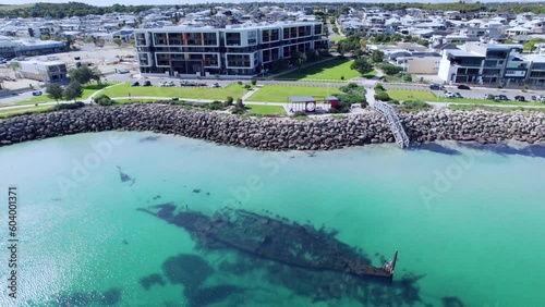 The Omeo wreck, a historic shipwreck located in Coogee, Western Australia. The wreck is surrounded by clear blue water and white sand, and the surrounding  modern apartment buildings photo