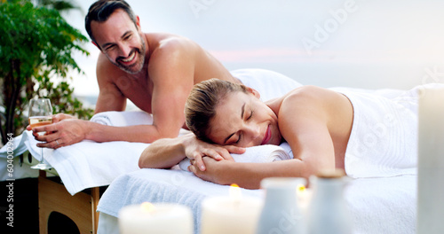 Love, spa and couple outdoor for massage, vacation and resting on table on a zen balcony. Relax, peace and man with woman at a luxury resort for wellness, treatment or body therapy, candles and wine