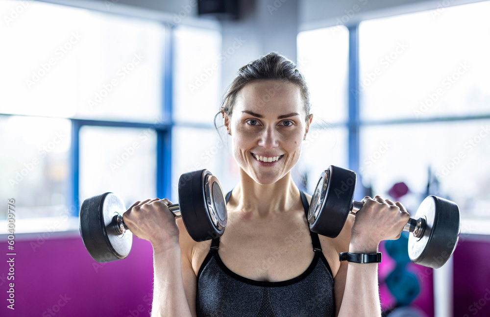 Young woman exercising with dumbbells in a health club
Young woman exercising with dumbbells in a health club