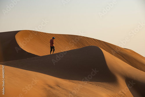 Walking in desert sand dunes, Wahiba Sands, Ash Sharqiyah, Oman photo