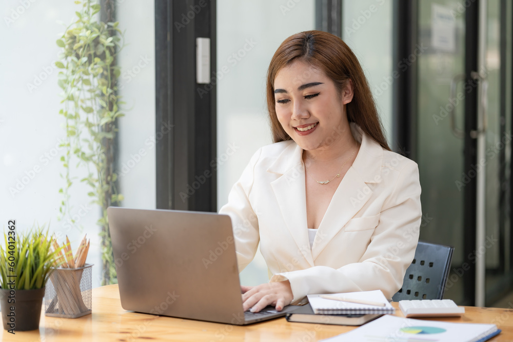 Asian Businesswoman working on a laptop at her desk at the office. Asian Businesswoman working on a laptop at her desk at the office.