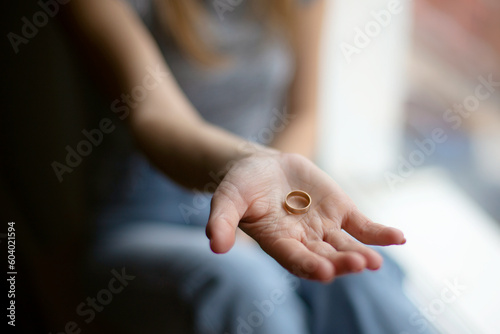 Close-up of a gold wedding ring on a woman's hand. The end of the relationship between a man and a woman.