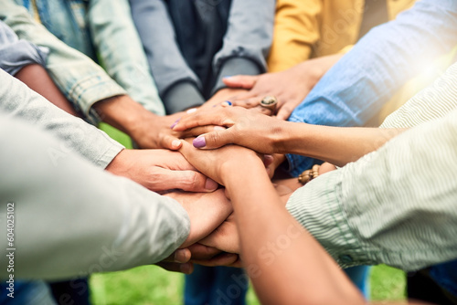 Friends, community and stack of hands of people for motivation, support and friendship goal outdoor. Teamwork, diversity and men and woman huddle together for trust, commitment and solidarity in park photo