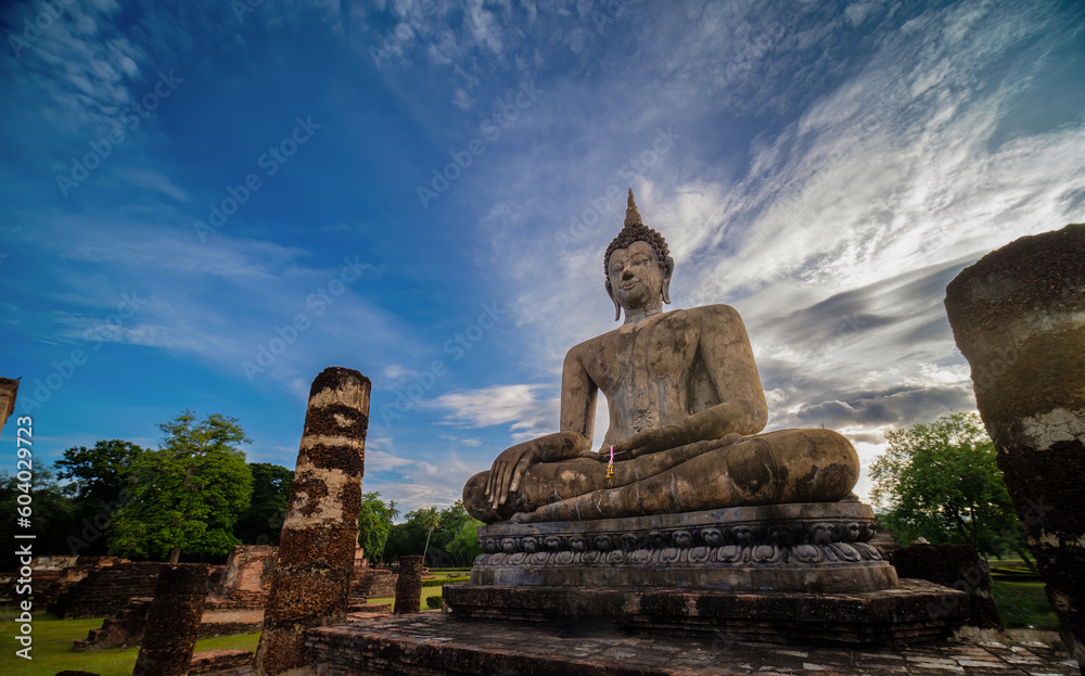 Wide view of sitting Buddha at sunset with blue sky and white cloud on background. UNESCO and World Heritage site. Travel concept.