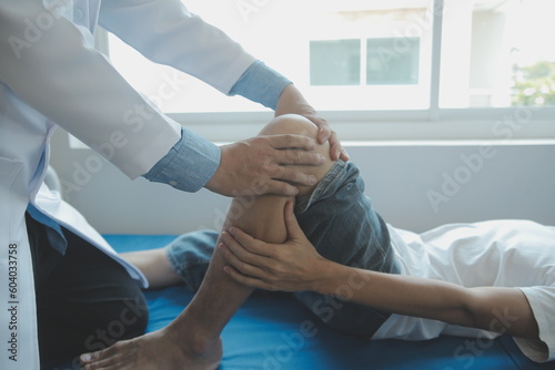 Doctor or physical therapist examines back pain and spinal area to give advice within the rehabilitation center.