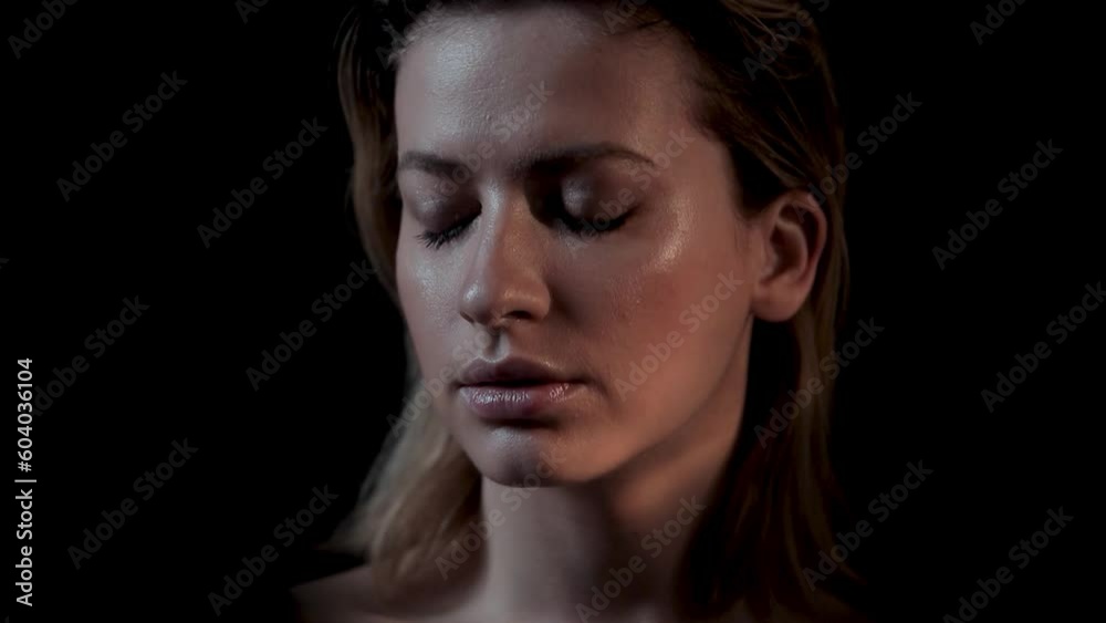 Young beautiful woman portrait with flickering light,caustic and light flashes on the face, black background Young beautiful woman portrait with flickering light,caustic and light flashes on the face, black background
