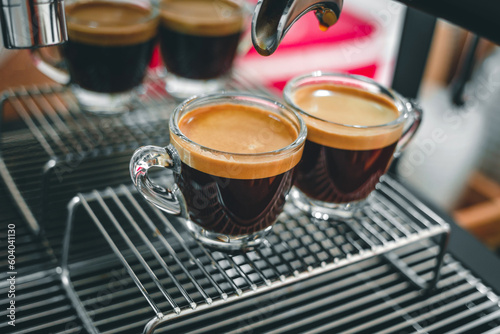 Professional espresso machine while preparing two espressos shot in a coffee shop. Close-up of espresso pouring from the coffee machine