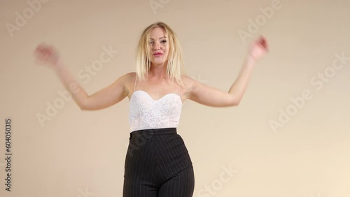 Sexy blonde in an open top with thin straps and smiling at the camera and playing with her blond hair. Blonde gerl makes eyes. Isolated. 4K Resolution