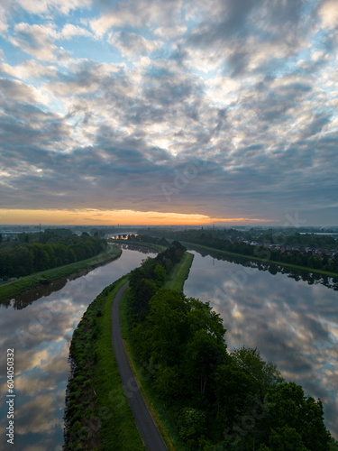 Aerial view of a colorful dramatic sunrise sky over the river Nete in Duffel  Belgium. River with water for transport  agriculture. Fields and meadows. River and forest landscape. High quality photo