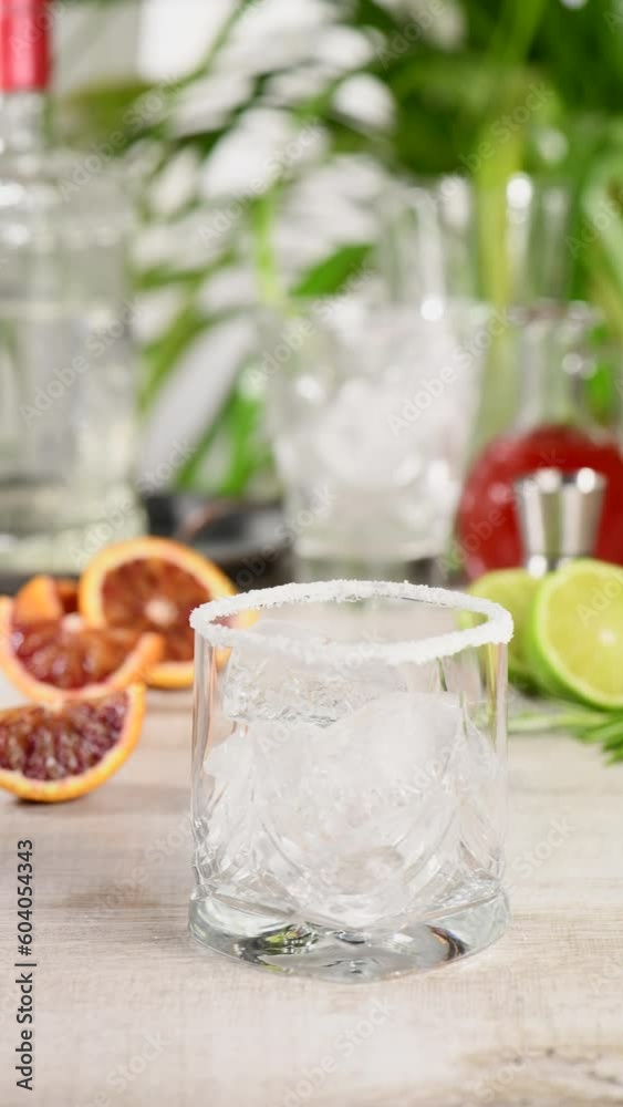 Preparation of a cocktail of tequila, fresh lime and rosemary with red Sicilian orange juice. This cocktail is full of bright citrus aromas and herbs. Indulge your palate with an excellent drink.