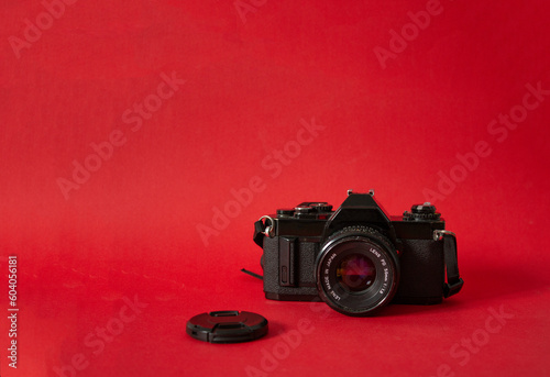 Analog film camera on red background