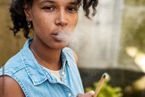 Short hair alternative woman smoking hashish joint photo