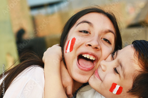 Happy peruvian kids with colors of peruvian flag on the cheek.