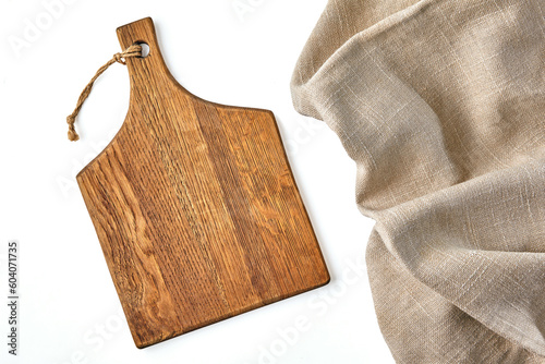 A beige wooden cutting board and a rough beige linen napkin on a