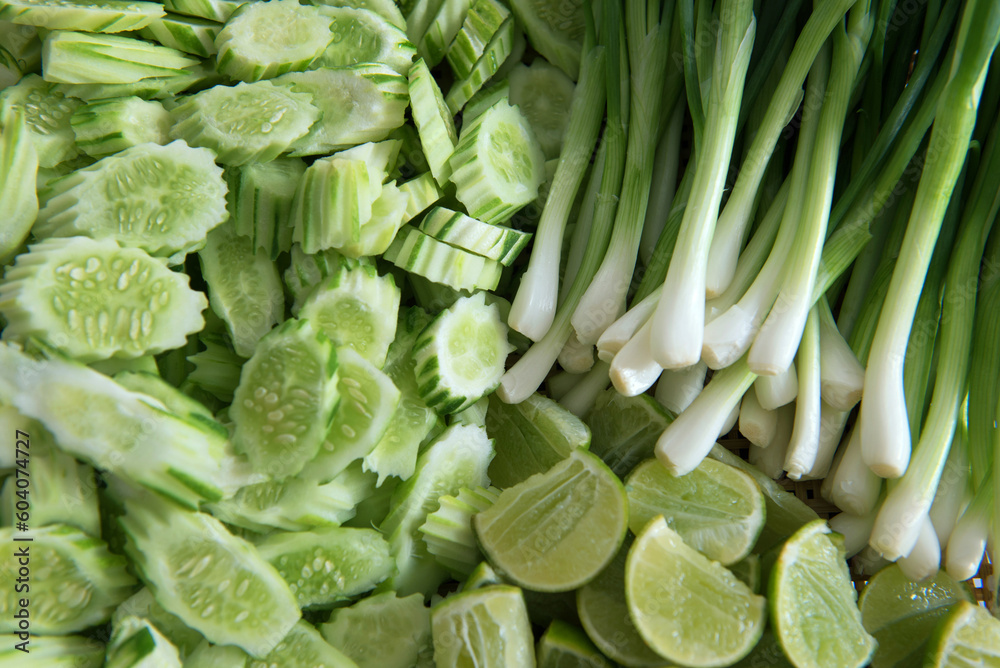 Obraz premium Closeup of freshly harvested vegetables (cucumber, lime, spring onion), top view
