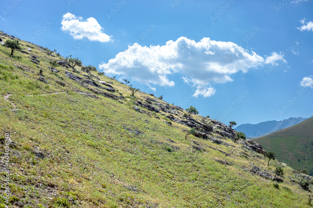 Mountain slope on a beautiful background of sky and clouds