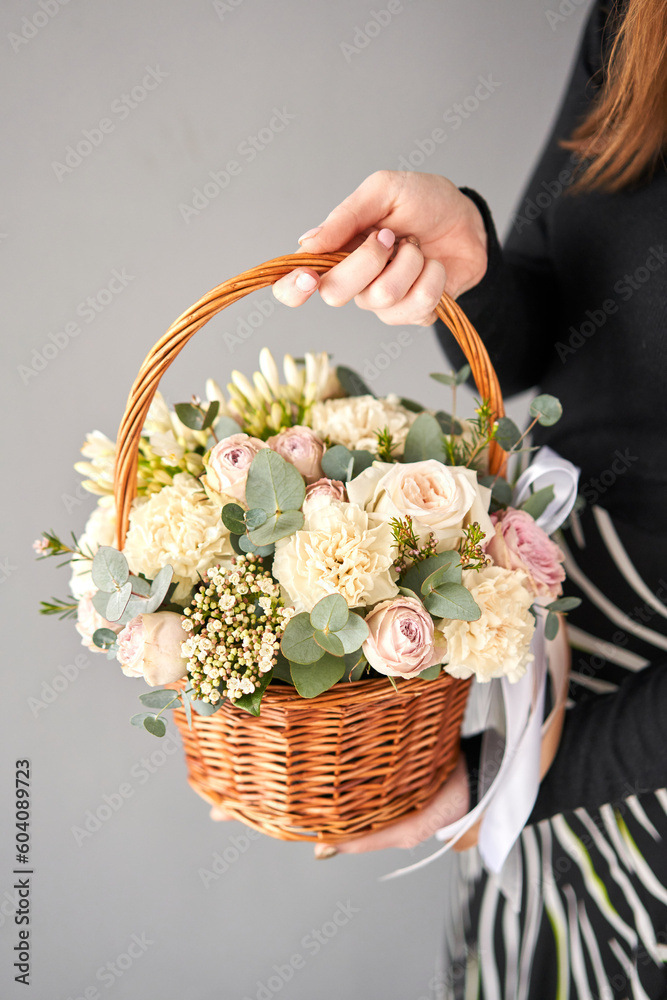 Small flower shop and Flowers delivery. Flower arrangement in Wicker basket. Beautiful bouquet of mixed flowers in woman hand. Handsome fresh bouquet.