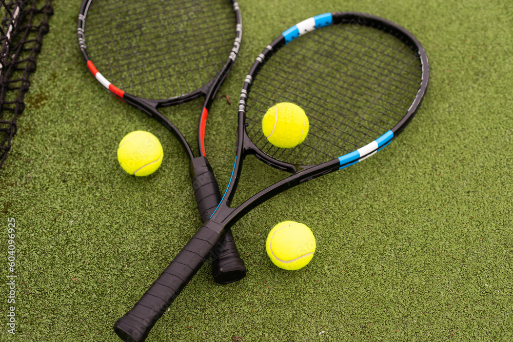 tennis racket with balls on green background.