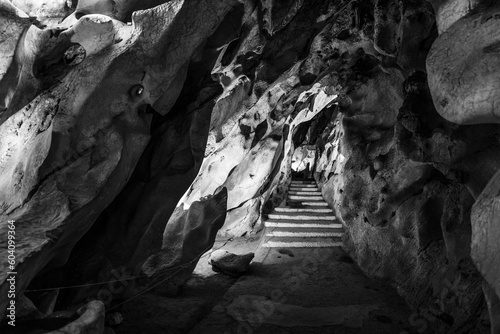 Black and white shot of stairs on a deep cave