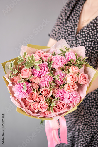 Fototapeta Naklejka Na Ścianę i Meble -  Beautiful bouquet of mixed flowers in woman hand. Floral shop concept . Beautiful fresh cut bouquet. Flowers delivery