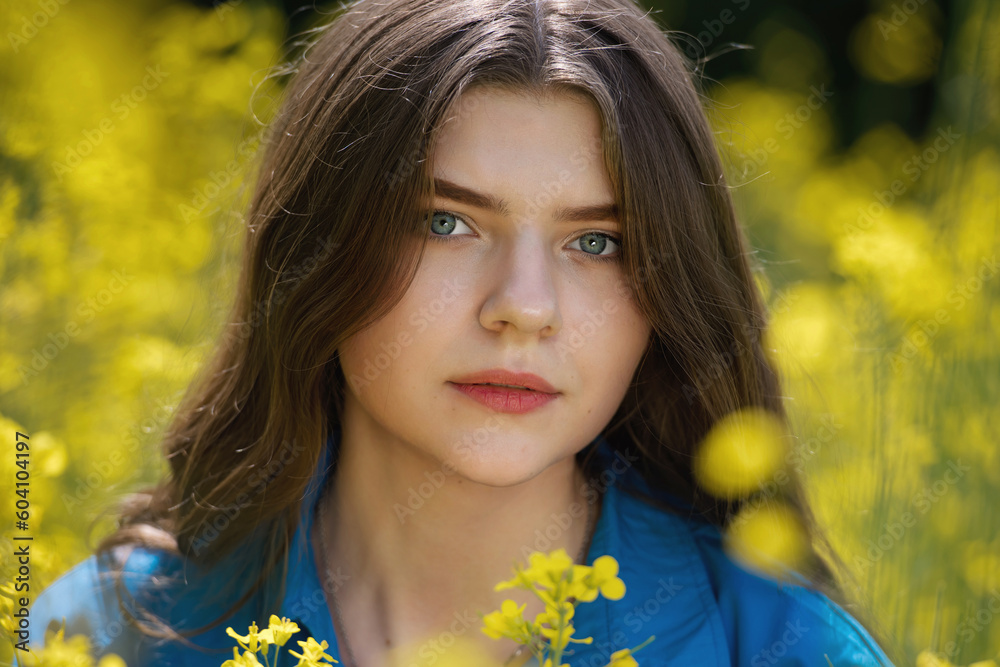 Portrait of a beautiful young woman surrounded by canola flowers. Portrait of a beautiful young woman surrounded by canola flowers.