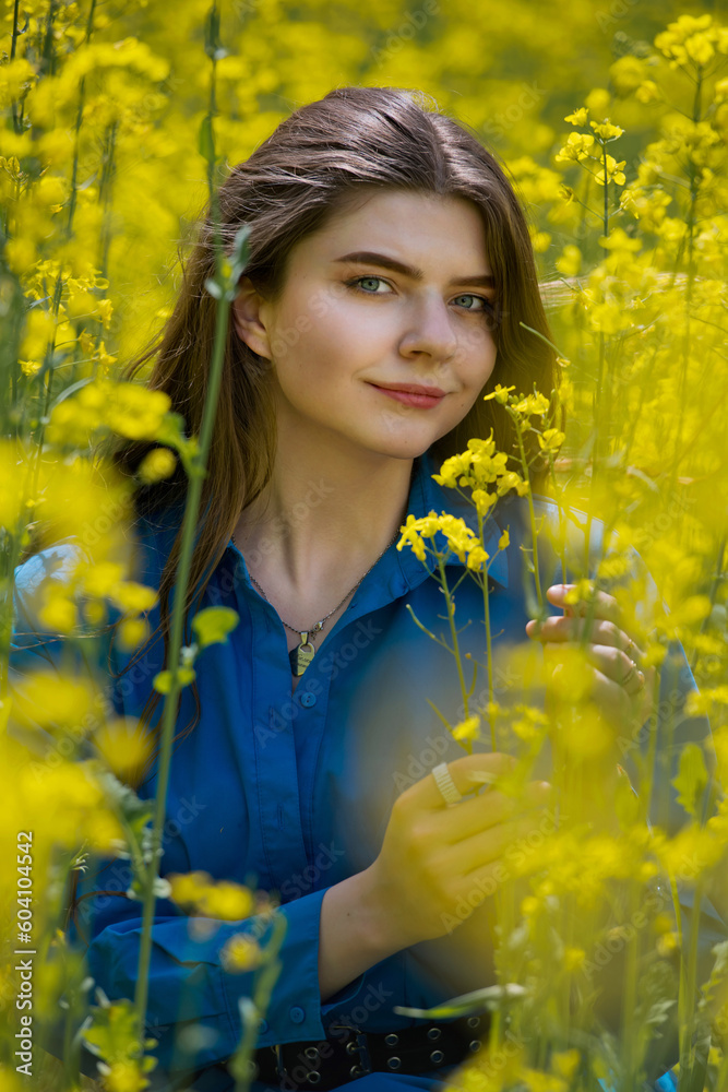 Portrait of a beautiful young woman surrounded by canola flowers. Portrait of a beautiful young woman surrounded by canola flowers.