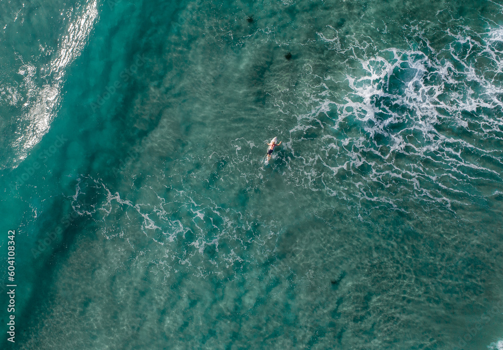View of a surfer in a blue ocean