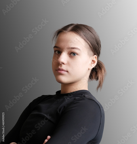 Judo girl with brown belt. A judoka teenager fighter poses in a blue kimono on a plain background. Japanese martial art. The process of martial arts training. Healthy lifestyle, sports concept
