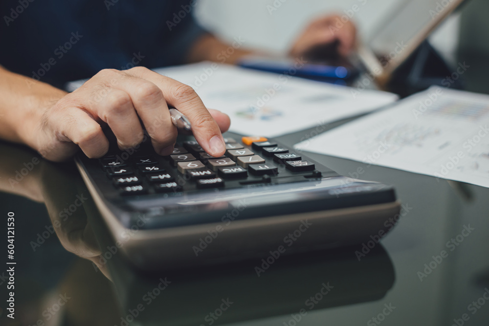 Businessman hands with calculator at the office and financial data analyzing business result and tax management. Finance accounting and economy concept. Businessman hands with calculator at the office and financial data analyzing business result and tax management. Finance accounting and economy concept.