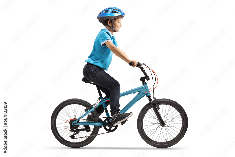 Fototapeta premium Profile shot of a boy riding a bicycle with a helmet