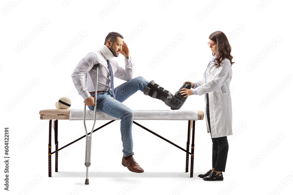 Obraz premium Female doctor putting on a walking brace to a male patient