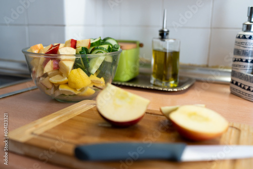 Cuenco de frutas y verduras cortadas en trozos y manzana