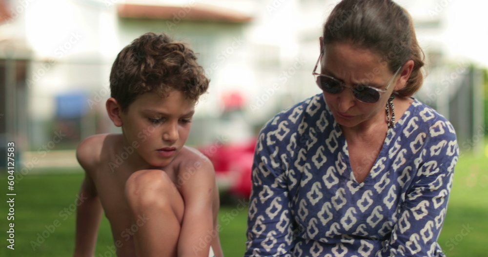 Kid learning to read. Mother helping young boy with homework Kid learning to read. Mother helping young boy with homework