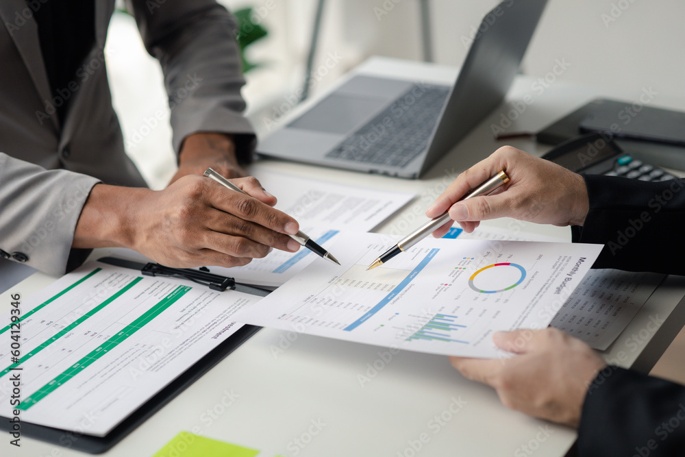 Two businessmen pointed to the material for the meeting, working together to plan to develop and solve common business problems. Concept of business management for growth and quality.