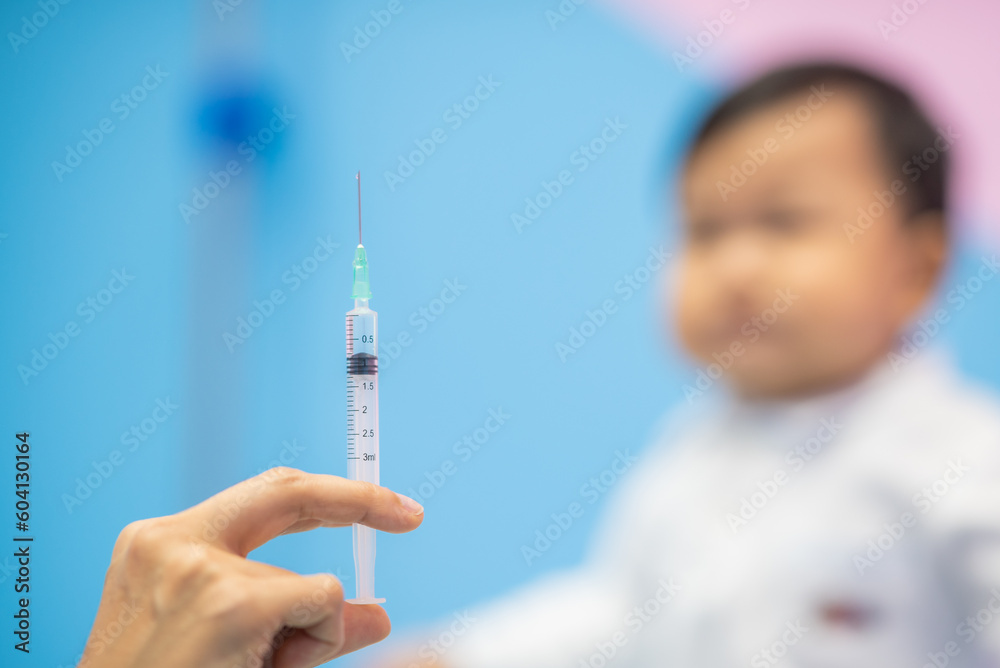 pediatrician Hand hold vaccine liquid injection in syringe for injecting child baby infant. small syringe needle for infant prevention flu by vaccination immunity in Pediatrics hospital clinic. pediatrician Hand hold vaccine liquid injection in syringe for injecting child baby infant. small syringe needle for infant prevention flu by vaccination immunity in Pediatrics hospital clinic.