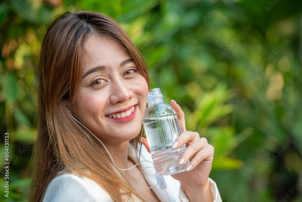 Asian woman drink clean fresh cold water from drinking plastic bottle. Drinking mineral water from bottle in hold hand and show. Asian woman drink clean fresh cold water from drinking plastic bottle. Drinking mineral water from bottle in hold hand and show.